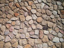 Beautiful texture with the colorful stones on the wall, in light