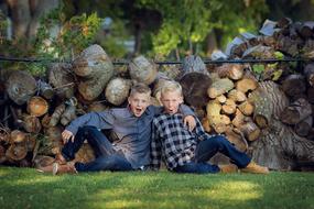 Two blond brothers on the green grass in the garden