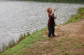 little boy with a fishing rod near the water