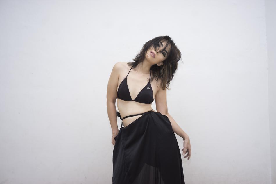 photo of a girl in a black bikini and black skirt