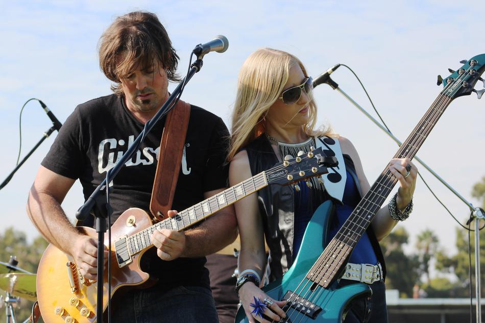 musicians with guitars on stage outdoors