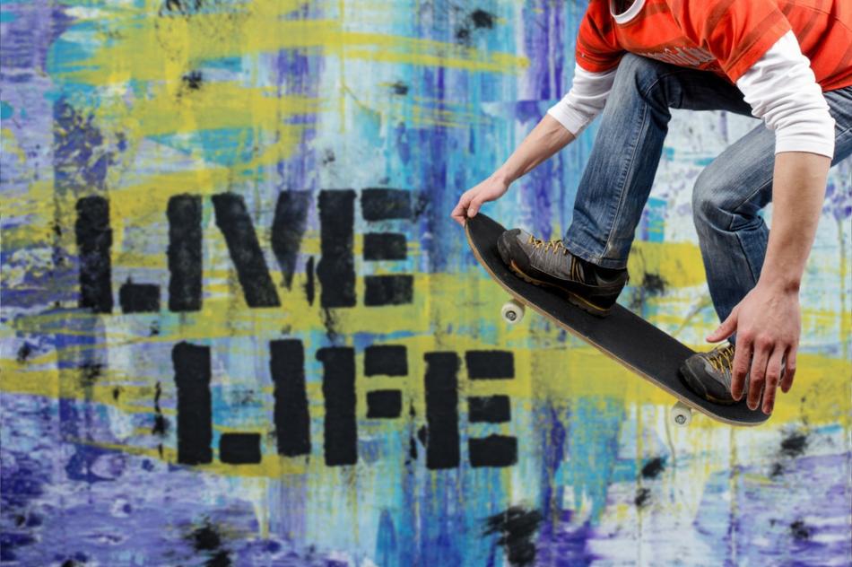 the guy on the skateboard near the wall with graffiti