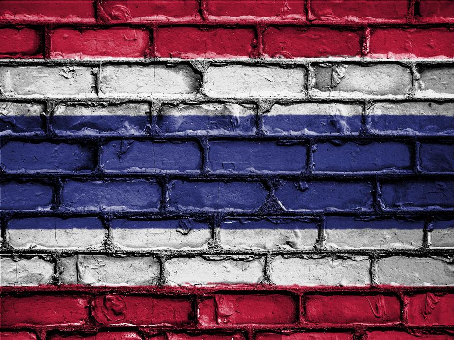 a stone wall with a red and blue floag.