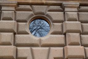 round window on the stone facade of the building