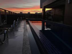 evening photo of the pool along the hotel