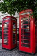 two traditional red phone booth beneath tree, uk, england, London