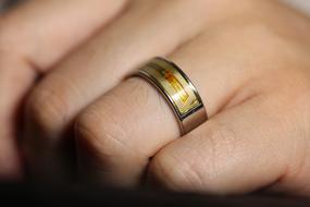 designer wedding ring on hand in blurred background