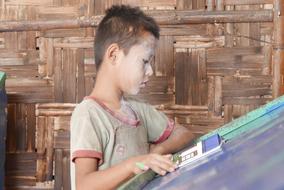 child standing reading a book