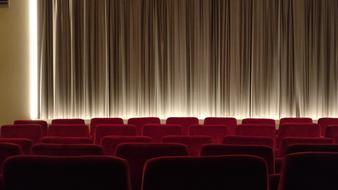 an empty hall with red chairs