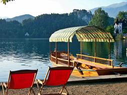 a boat by the red chairs with water