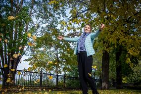 nice young Girl plays with autumn leaves in park