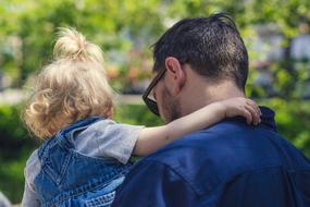 dad holds a little daughter in his arms