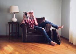 Person reading a newspaper on the armchair