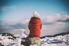 child girl Sitting Alone at snowy winter