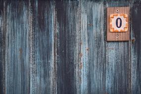 Old, colorful sign with the "0" number, on the colorful, old wall