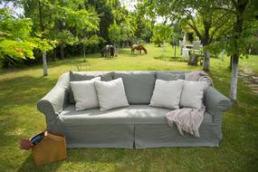 a sofa with pillows is in the yard