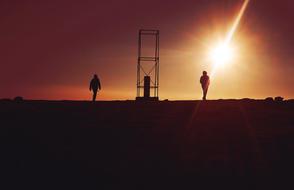 Silhouette of People Walking beside of tower at sunset sky