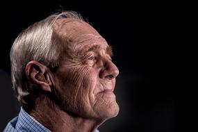 wrinkled Old man, portrait at dark background