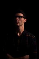 portrait of a man with glasses in the dark