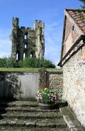 an old castle with a house and flowers