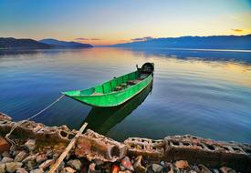 green boat by the shore with the sea