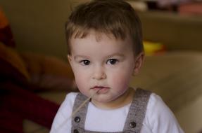 photo of a little boy with a straw in his mouth