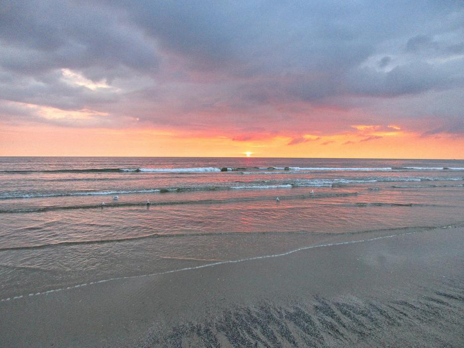 the sun sets over the sea