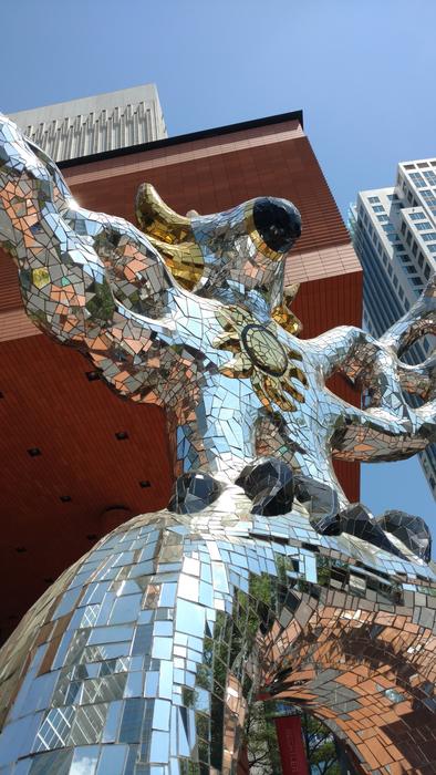 Beautiful, shiny, mirrored statue of the bird, under the blue sky