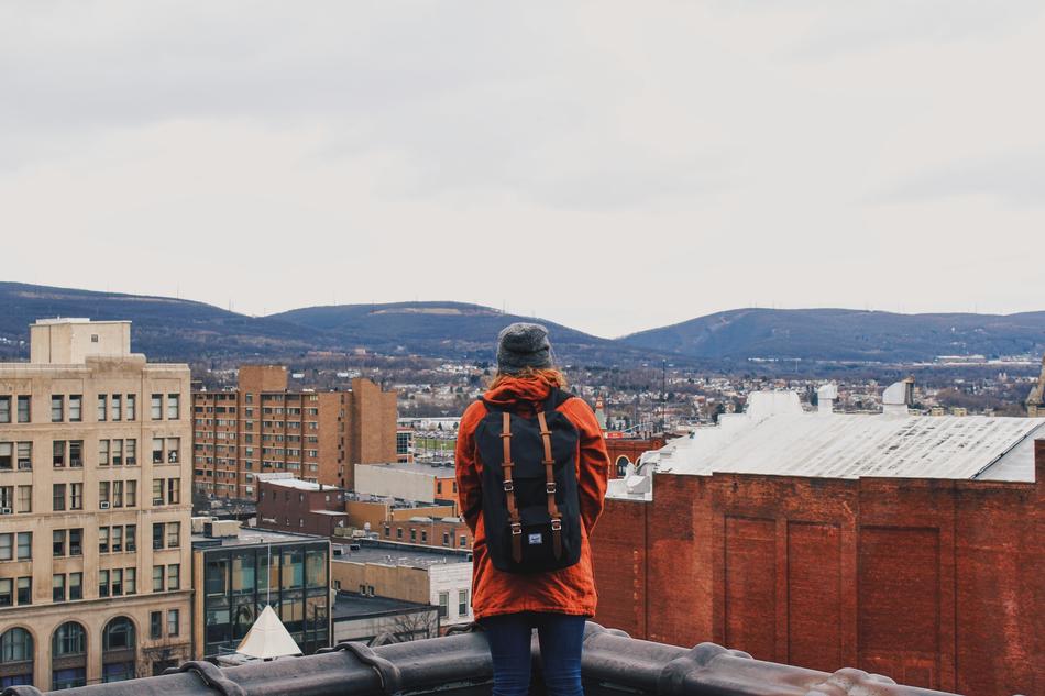 girl with herschel backpack on building roof