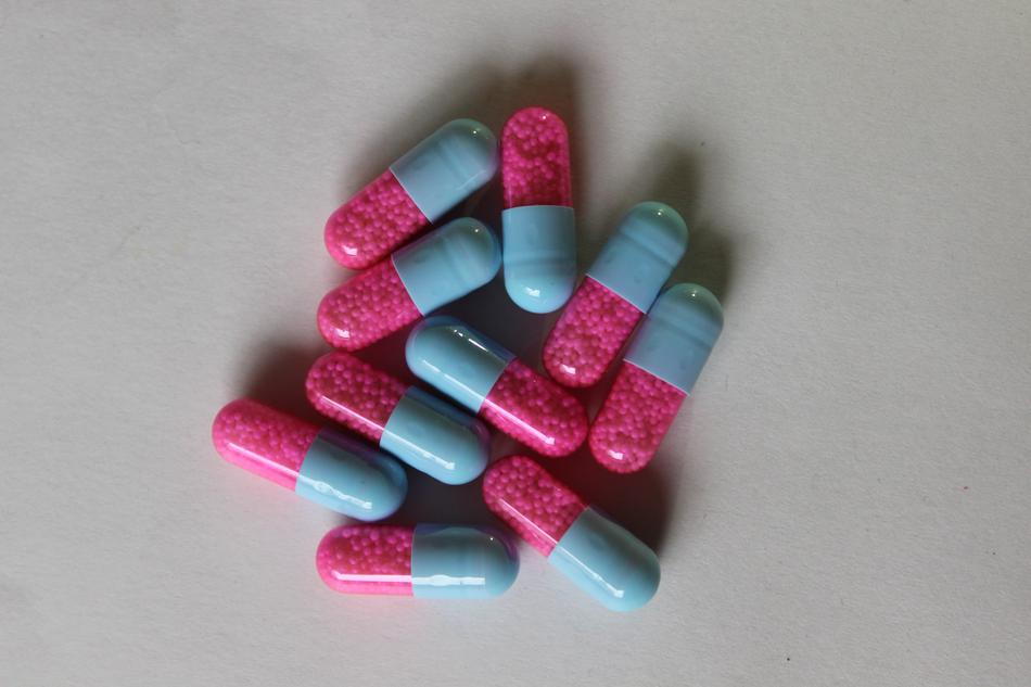 Close-up of the shiny, turquoise and pink pills, with the shadows,