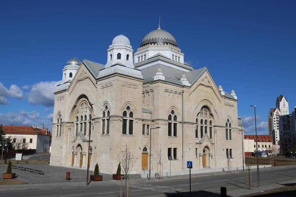 Beautiful synagogue at blue sky with white clouds background among the buildings