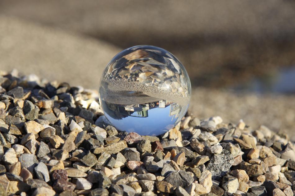 Beautiful glass ball, with the view of the building, on the colorful stones