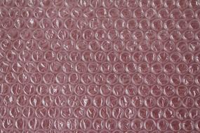Close-up of the transparent packaging, at red background