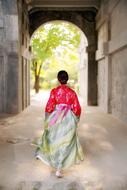 Korean girl in colorful Hanbok walking to the arch