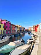 boats by the sea with colored houses