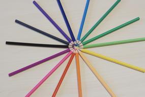 Pattern of the colorful and beautiful pencils, with the center, on the wooden surface