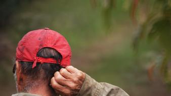 old man scratching nape, blur background