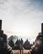 young man stands in front of ancient buddhist temple