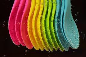 colorful plastic spoons in water close-up