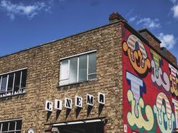 Beautiful brick building with cinema sign and colorful graffiti