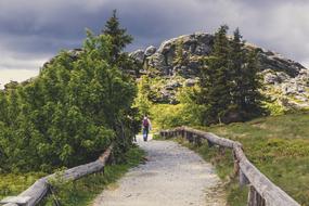 People walking on hiking trail to scenic mountains