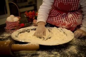 Child kneading dough in the big bowl