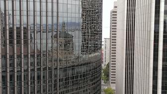 reflection of the promenade on the facade of a glass skyscraper