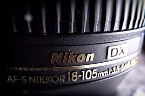 golden logo on black lens close up