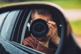 man with Camera in window of car, Photographer