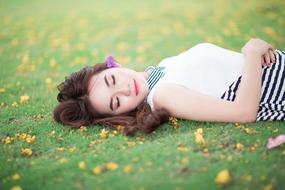 pretty young Girl laying on back on lawn