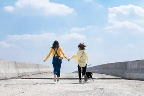 two friends with a dog for a walk