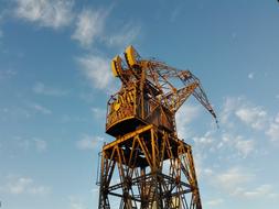 yellow industrial crane on a clear blue sky background