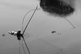 fisherman with net on rod in water