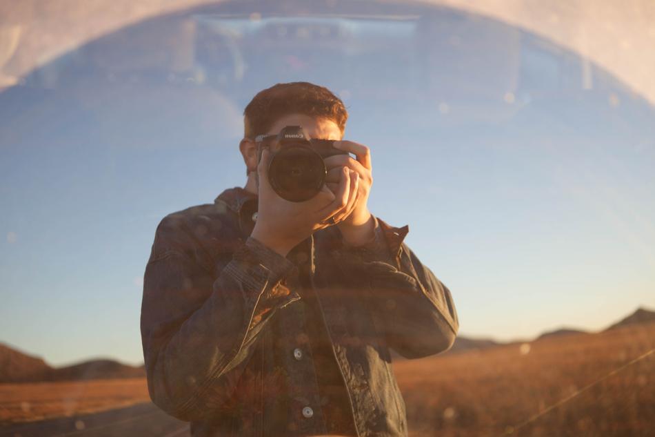 Man photographer the reflection in the glass